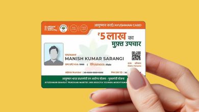 Elderly Indian man holding Ayushman Vay Vandana Health Card with hospital in background