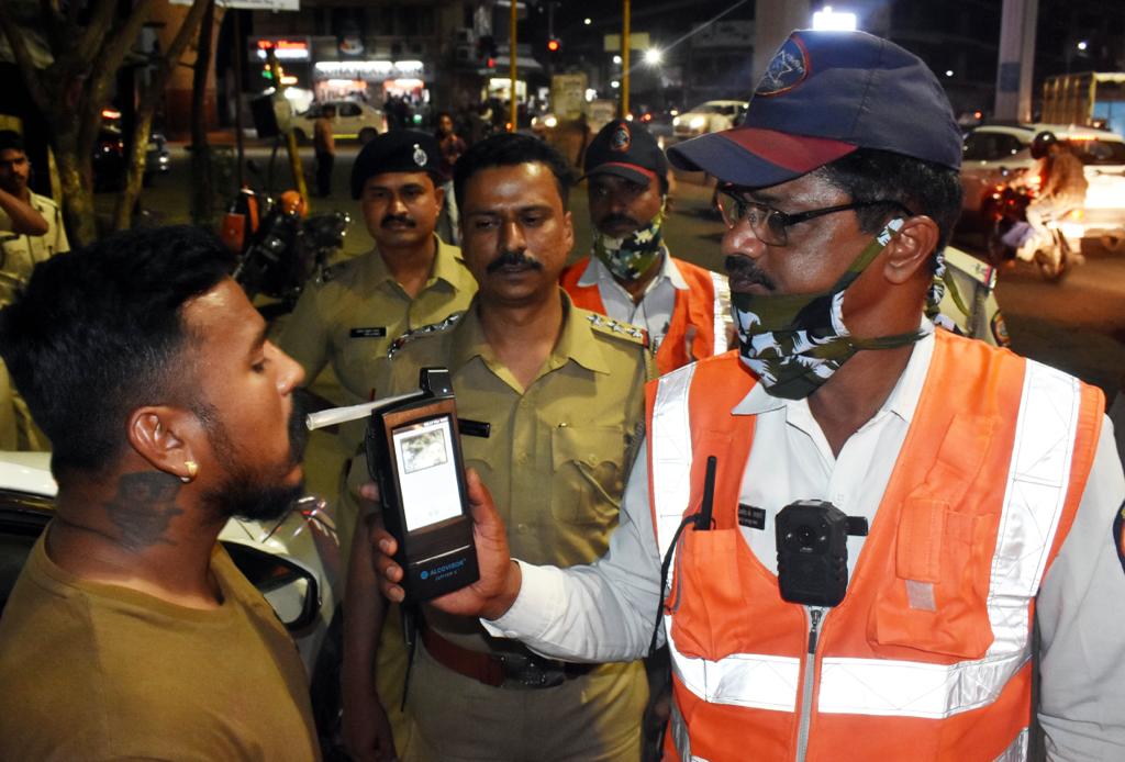 A police officer stopping a car on a road, symbolizing enforcement against drunk driving during festivals.