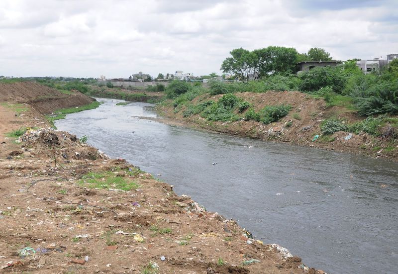 A clean river flowing through urban landscape, symbolizing environmental restoration efforts in Nagpur.