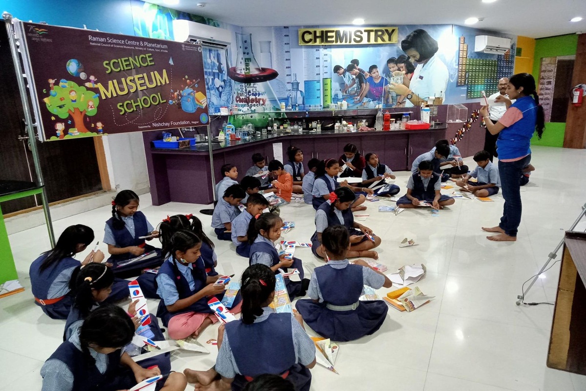 A vibrant and modern science centre bustling with enthusiastic children exploring scientific exhibits.