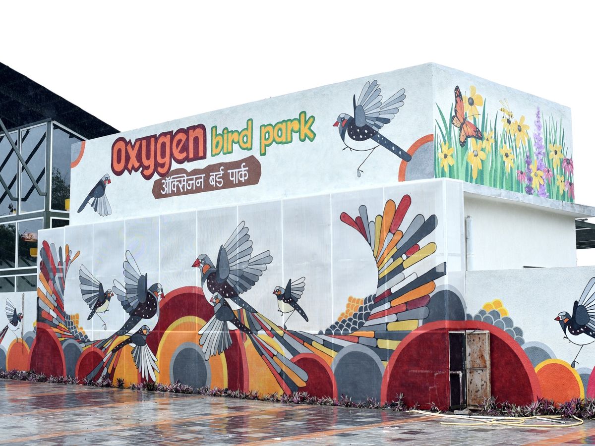 Amrit Mahotsav: A serene view of the Oxygen Bird Park with lush green trees and birds flying.