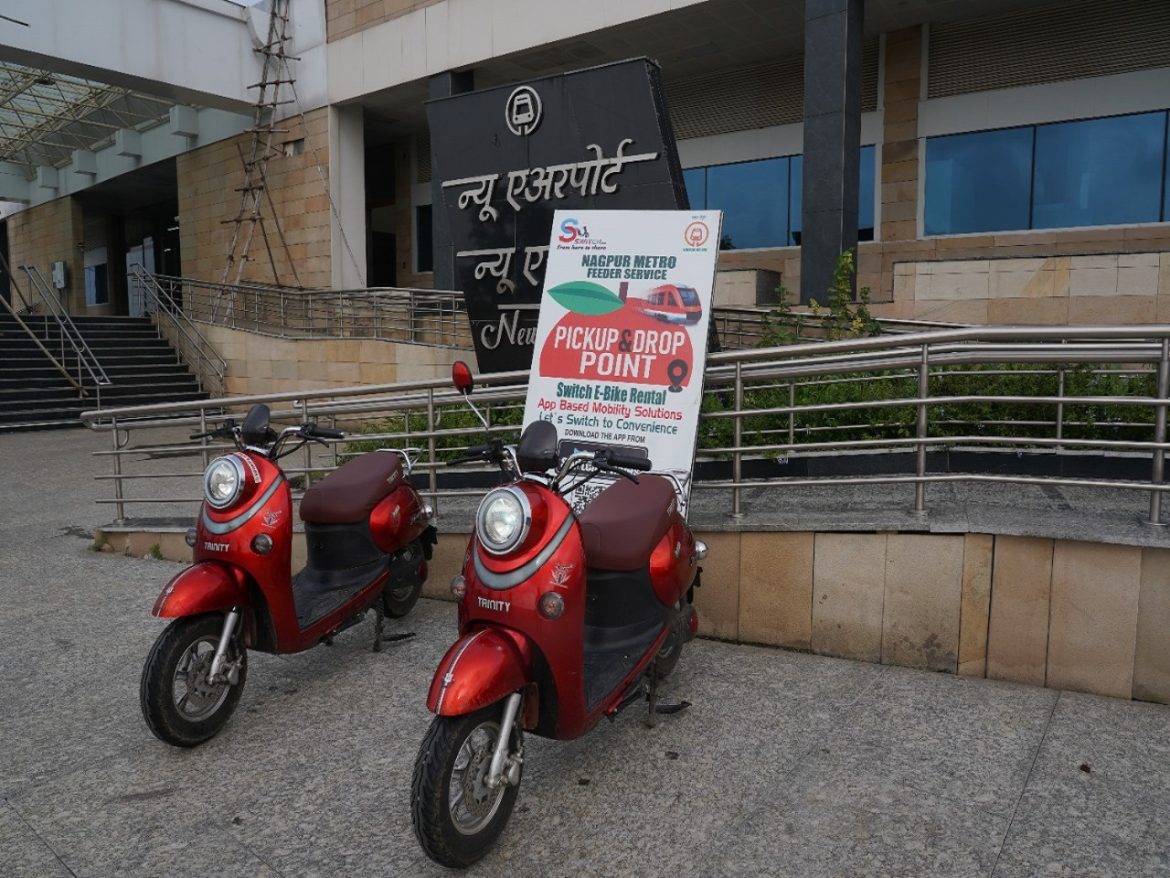 Commuter using a Switch E-Ride e-scooter near a MahaMetro station.