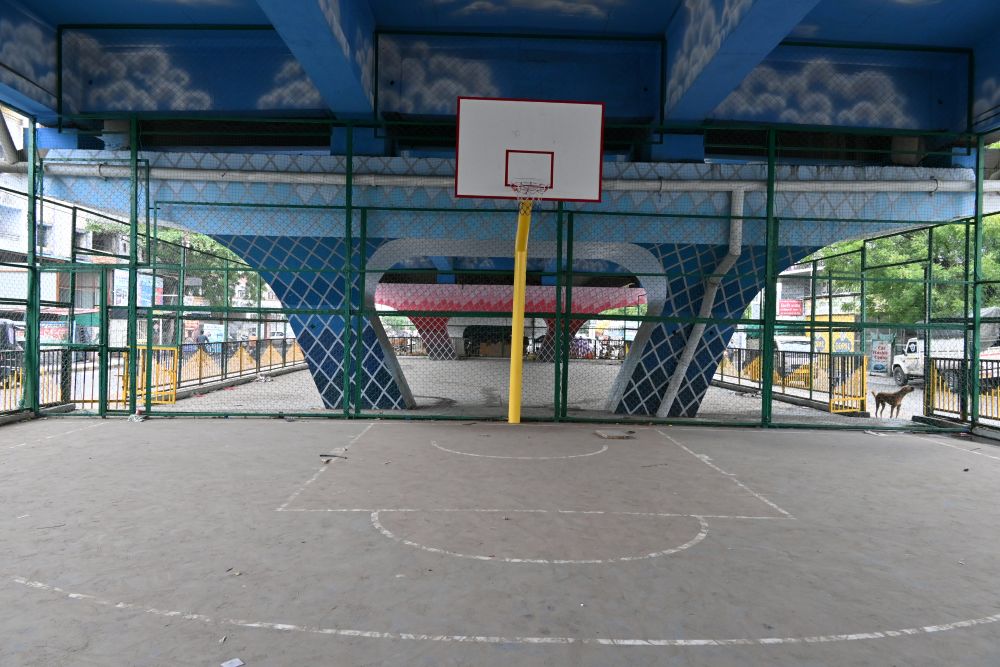 Transformed flyover space in Nagpur featuring a basketball court, green seating areas, and a public gym setup