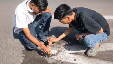 Shegaon engineering students Rajvardhan Thakur and Atharv Deshmukh demonstrate bio-based self-healing road and glow-based night visibility technology near Sant Gajanan Maharaj Temple Shegaon 2026